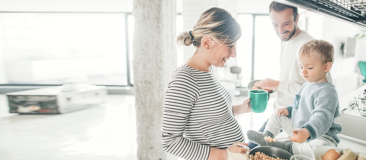 Junges Paar und Kleinkind sind in der Küche und kochen