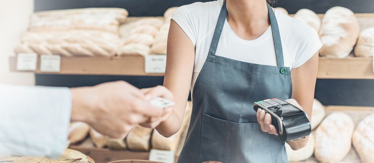 Bäckerin kassiert mit Kartenterminal